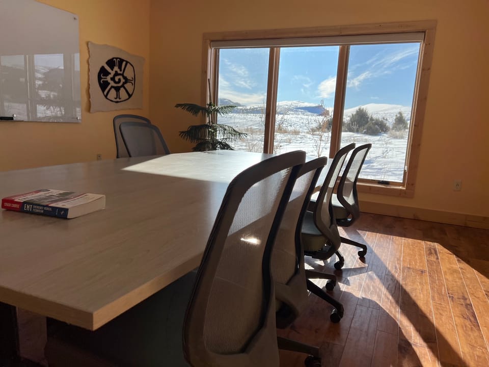 A view of a conference room with an open window looking out onto a snowy landscape.